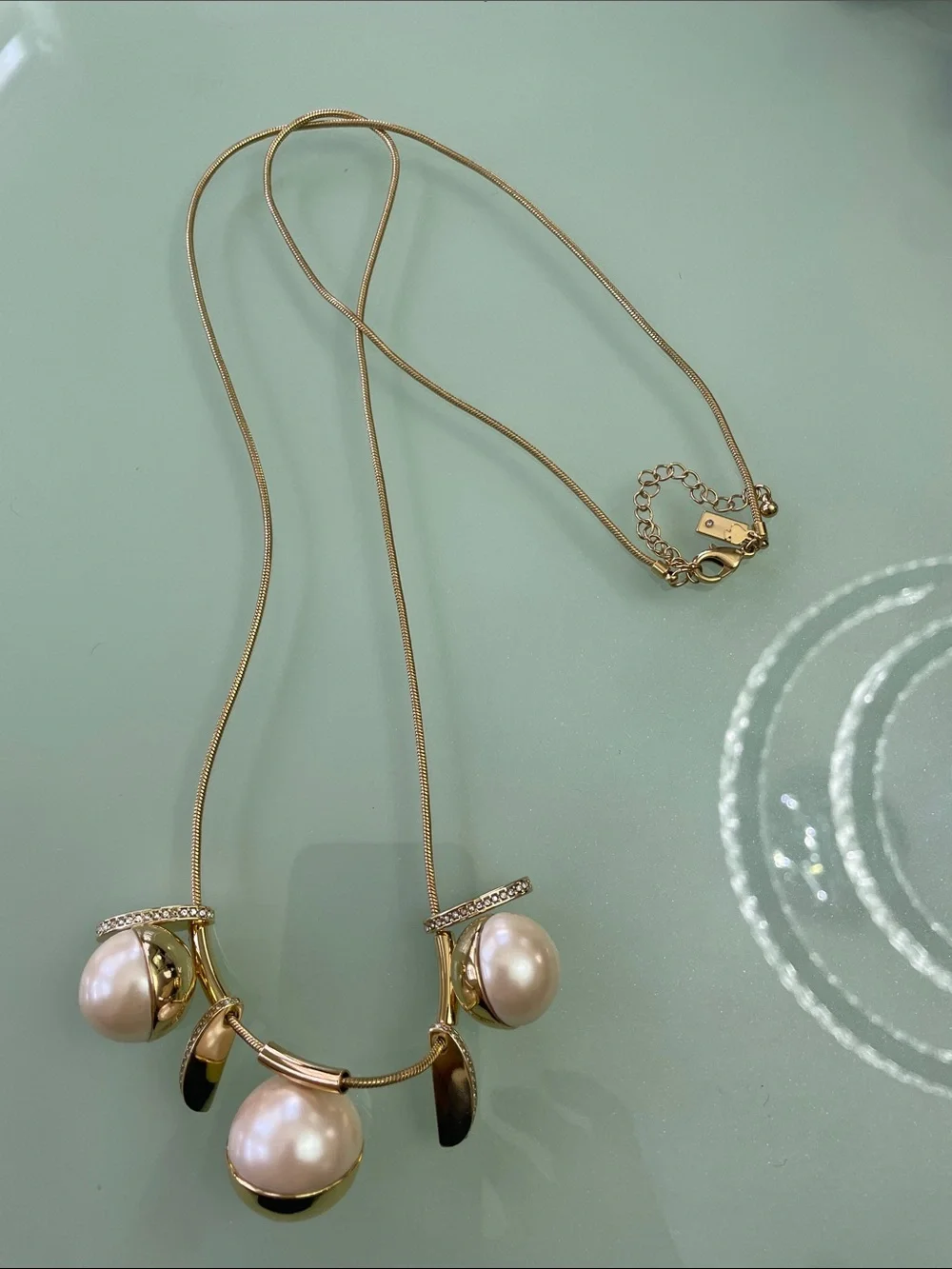 Kate Spade New York Pendant in gold with pearls long chain.